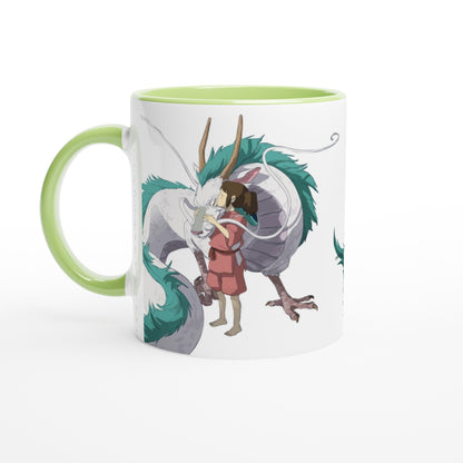 A white mug depicts Chihiro hugging Haku, a dragon from Spirited Away, inspired by Studio Ghibli.