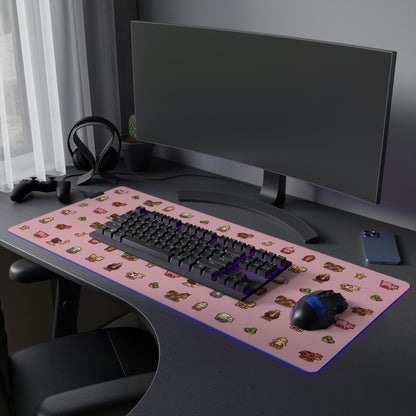 A pink Stardew Valley desk mat featuring pixel art animals sits on a black desk alongside a computer monitor, keyboard, mouse, and gaming accessories.