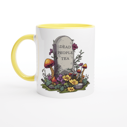 A white ceramic mug with a yellow handle and rim features an illustration of a tombstone inscribed with "Dead People Tea" surrounded by mushrooms and flowers.