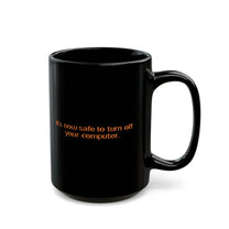 A black mug featuring the orange text It's now safe to turn off your computer.