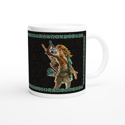 A white ceramic mug displays an illustration of Link from The Legend of Zelda: Tears of the Kingdom wielding a weapon against a background of Sheikah script and circular patterns.