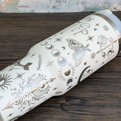 A white Witchy Boho engraved tumbler features celestial designs including stars, moons, and crystals.