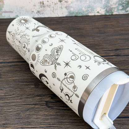 A silver Witchy Boho engraved tumbler features a celestial design of stars, moons, and other magical symbols.