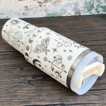 A silver tumbler featuring a celestial design of stars, moons, and crystals evokes a witchy boho aesthetic.