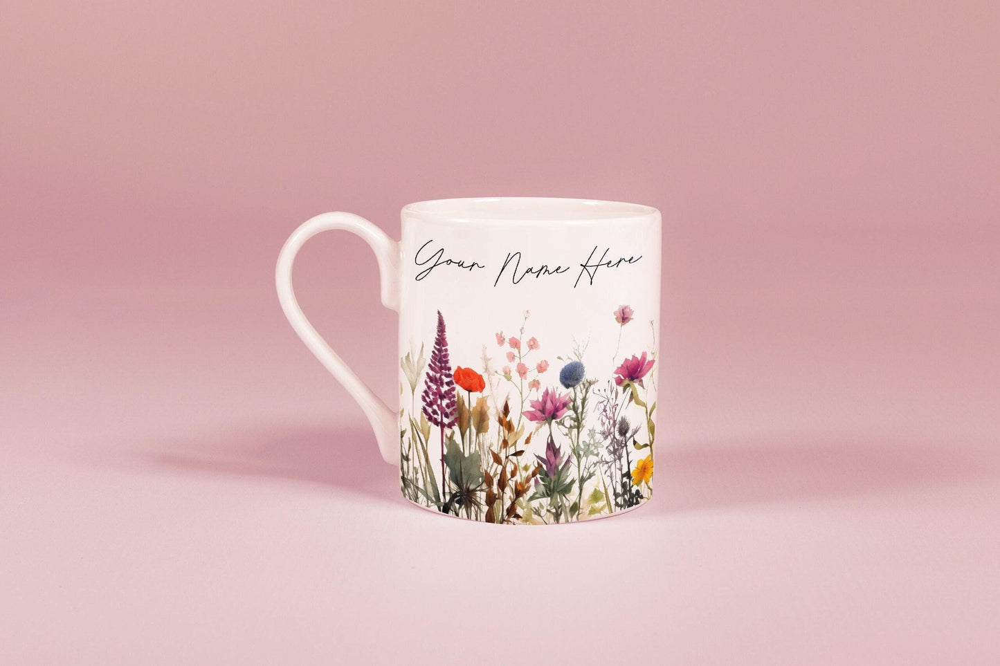 A white china mug features a watercolour floral design of wildflowers and the text "Your Name Here".