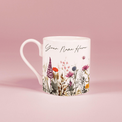 A white china mug features a watercolour floral design of wildflowers and the text "Your Name Here".