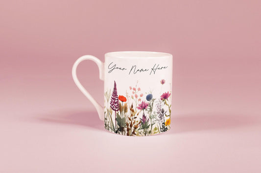 A white china mug features a watercolour floral design of wildflowers and the text "Your Name Here".