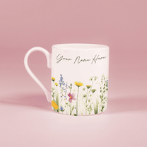 A white china mug features a watercolour floral design of wildflowers along with the text "Your Name Here".
