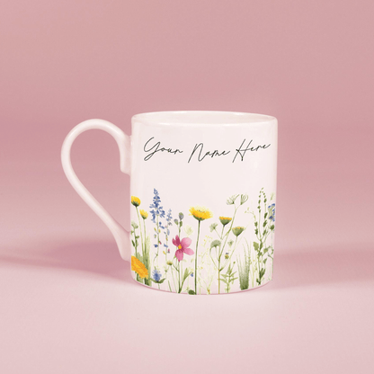A white china mug features a watercolour floral design of wildflowers along with the text "Your Name Here".