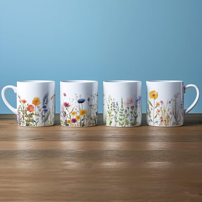 Four white china mugs display a watercolour floral design depicting a wildflower meadow.