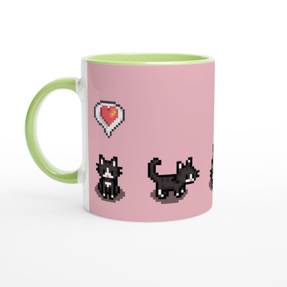 A white mug has a pink surface decorated with pixelated graphics of tuxedo cats and a heart, referencing the Stardew Valley computer game.