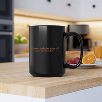 A black mug featuring the orange text It's now safe to turn off your computer.