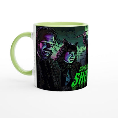 A ceramic mug displays an illustration of Laszlo and Nadja from What We Do In The Shadows, posed dramatically against a dark background.