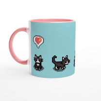 A ceramic mug features pixelated graphics of tuxedo cats and a heart emote referencing the Stardew Valley computer game.