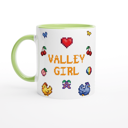 A white coffee mug features pixel art icons from Stardew Valley including chickens, cherries, a heart, and the words "Valley Girl.