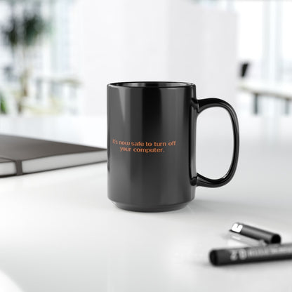A black mug displays the Windows 95/98 message "It's now safe to turn off your computer" in orange lettering.