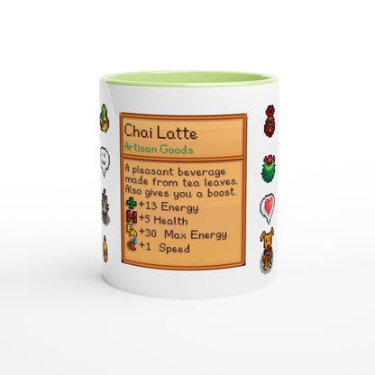 A white mug with a green rim features a Stardew Drinks pattern depicting a Chai Latte recipe card with pixelated sprites and stats.