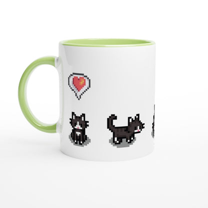A white mug with a green handle features pixelated graphics of tuxedo cats and a heart, referencing the Stardew Valley computer game.