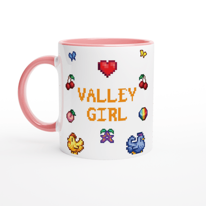 A white coffee mug features pixel art icons from Stardew Valley including cherries, a heart, and the words "Valley Girl" in a retro font.