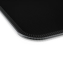 A close-up view of the stitched edge of a black Stardew Valley Tuxedo Cats LED Cosy Gaming Desk Mat.