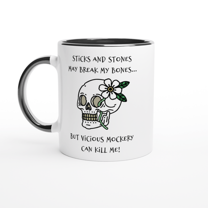A white mug with a black rim and handle features a skull illustration adorned with a flower and text referencing "Sticks and Stones" and "Vicious Mockery" from Dungeons and Dragons.