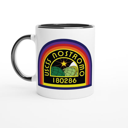 A white ceramic mug displays a rainbow-colored logo featuring the USS Nostromo name and number 180286 referencing the Alien movie universe.