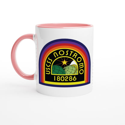 A white ceramic mug with a pink handle and rim displays the USS Nostromo logo, featuring stylized planetary rings and the number 180286.