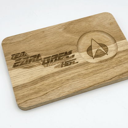 A wooden chopping board displays "Tea, Earl Grey, Hot" engraved lettering and a Star Trek delta shield emblem.