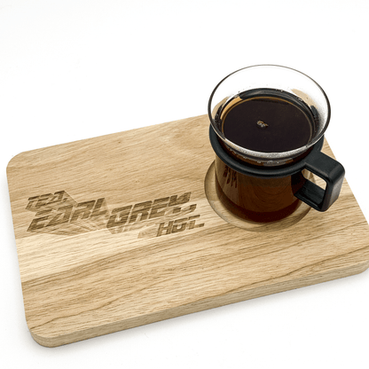 A wooden chopping board labeled "Tea, Earl Grey, Hot" sits next to a glass of dark tea referencing Star Trek: The Next Generation.