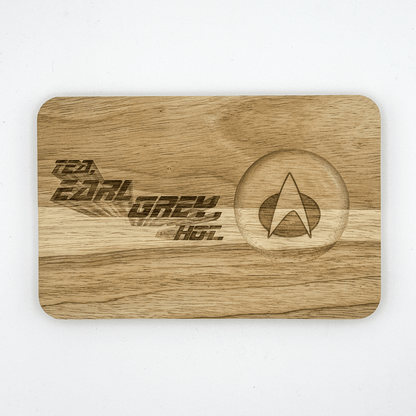 A wooden chopping board features laser-engraved text reading "Tea, Earl Grey, Hot" alongside a Star Trek delta shield logo.