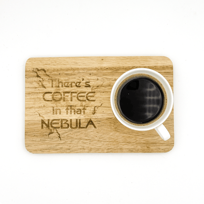 A wooden Voyager breakfast board features laser-engraved text reading "There's Coffee in that Nebula" and holds a white mug filled with black coffee.
