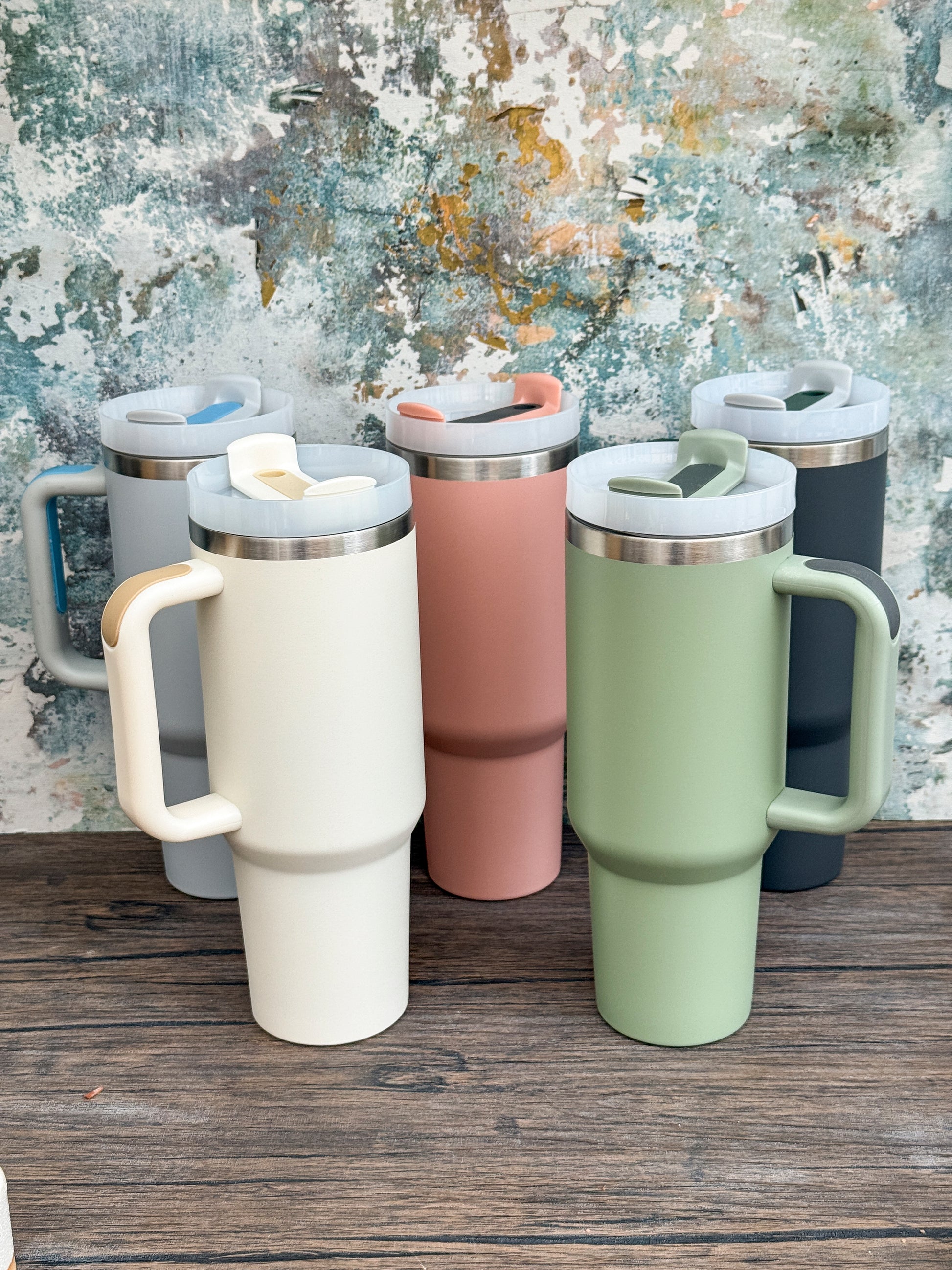 Six Witchy Boho engraved tumblers in various colors including cream, pink, and green are lined up on a wooden surface.