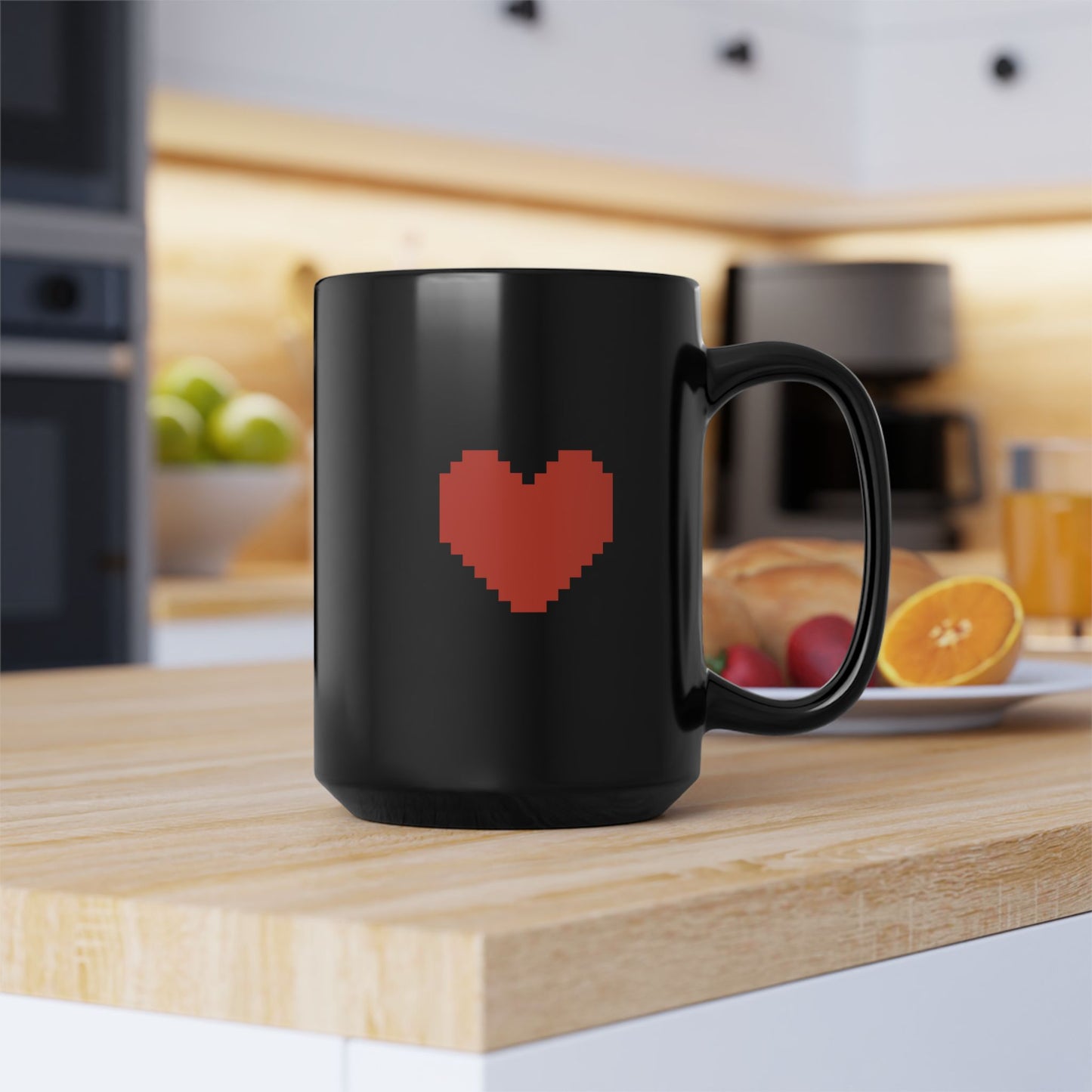 A black Undertale mug displays a pixelated red heart graphic on its surface and sits on a wooden countertop in a kitchen setting.