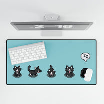 An extra large desk mat featuring a black and white pixelated pattern of tuxedo cats from Stardew Valley alongside a keyboard, mouse, and monitor.