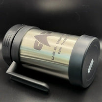 A silver travel mug resembling a thermos features the Star Trek delta shield logo and "U.S.S. Defiant NX 74205" printed on its surface