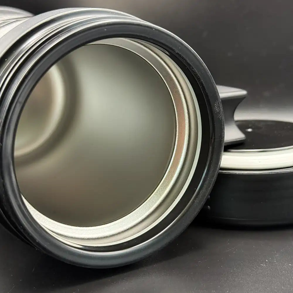 A close up of silver travel mug resembling a thermos features the Star Trek delta shield logo and "U.S.S. Defiant NX 74205" printed on its surface