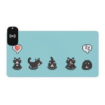 A light blue gaming desk mat featuring pixelated tuxedo cats from Stardew Valley in various poses with a wireless charging pad positioned on the left side.