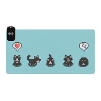 A light blue gaming desk mat featuring pixelated tuxedo cats from Stardew Valley and an integrated LED wireless charging pad.