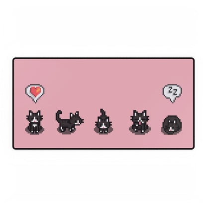 A pink extra large desk mat features a pattern of pixelated tuxedo cats from Stardew Valley with heart and sleep icons.