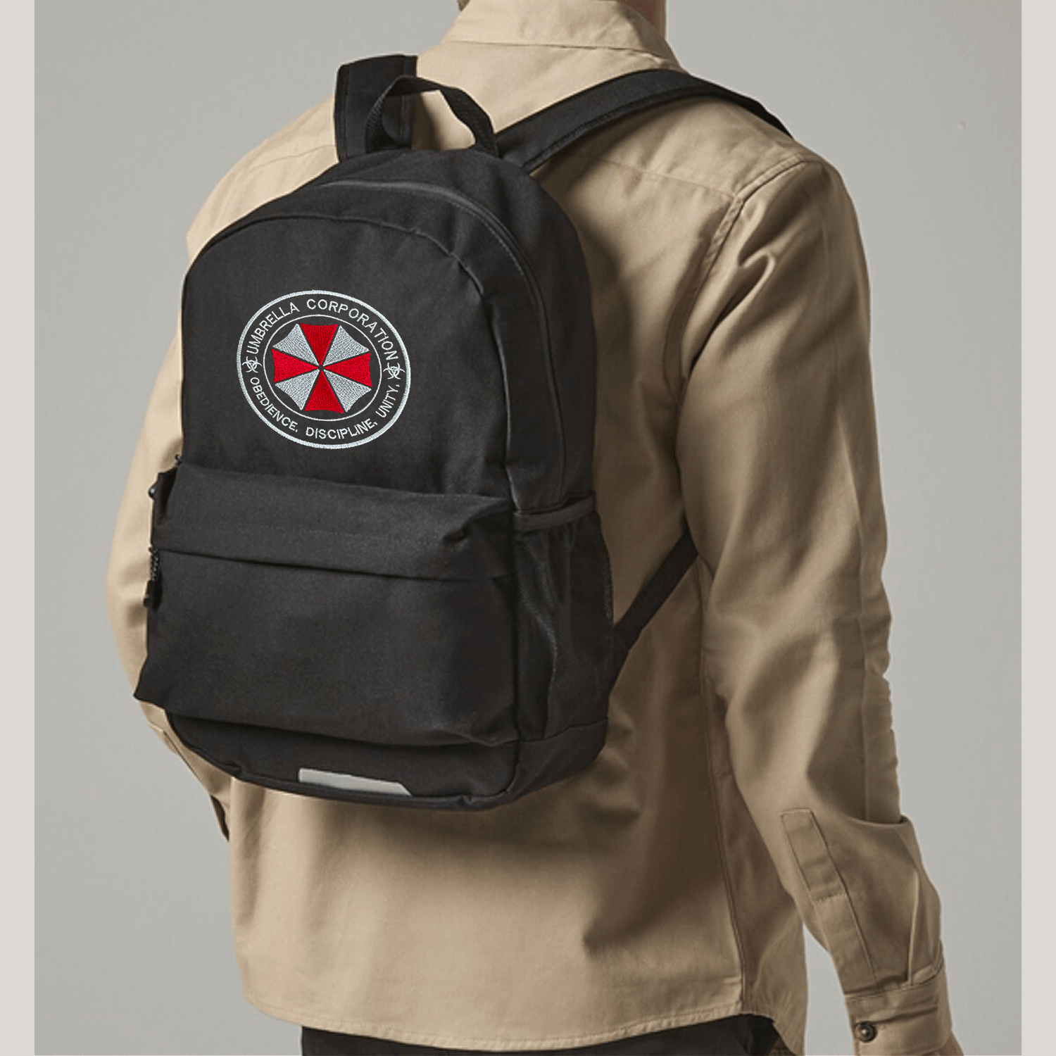 Person wearing a black backpack with Umbrella corporation logo on a gray background