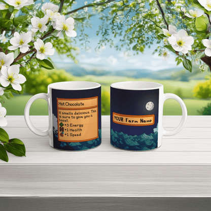 A white Stardew Custom Farm mug displays a hot chocolate design on one side and a mountain scene with customizable farm name on the other.