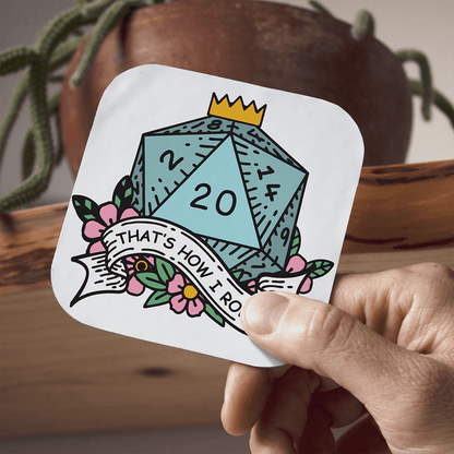Coaster with a DnD D20 die design held by a hand, with a plant in the background