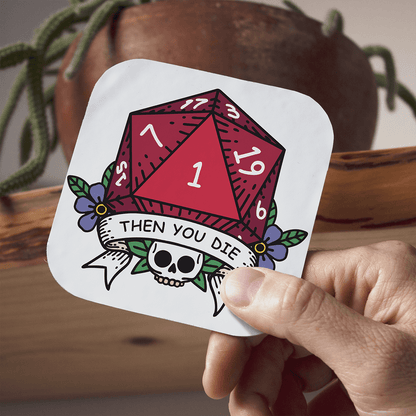 Sticker with a red DnD D20 die and skull design held by a hand, with a plant and wooden surface in the background.