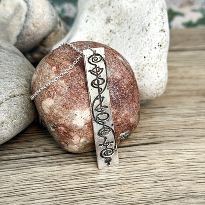 Star Trek IDIC sterling silver necklace with a vulcan calligraphy etched design on a rock