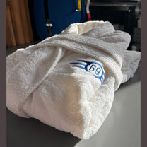 A white folded bathrobe featuring a blue Vault-Tec logo with the number 69 from the Fallout video game series.