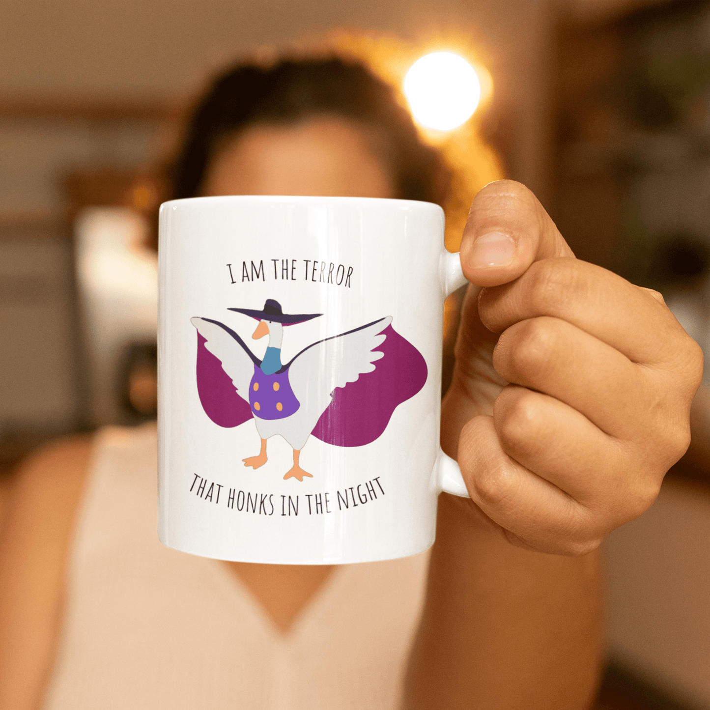 Darkwing duck / Untitled Goose white mug with 'I am the terror that honks in the knight' being held in the hand of a woman out of focus in the background