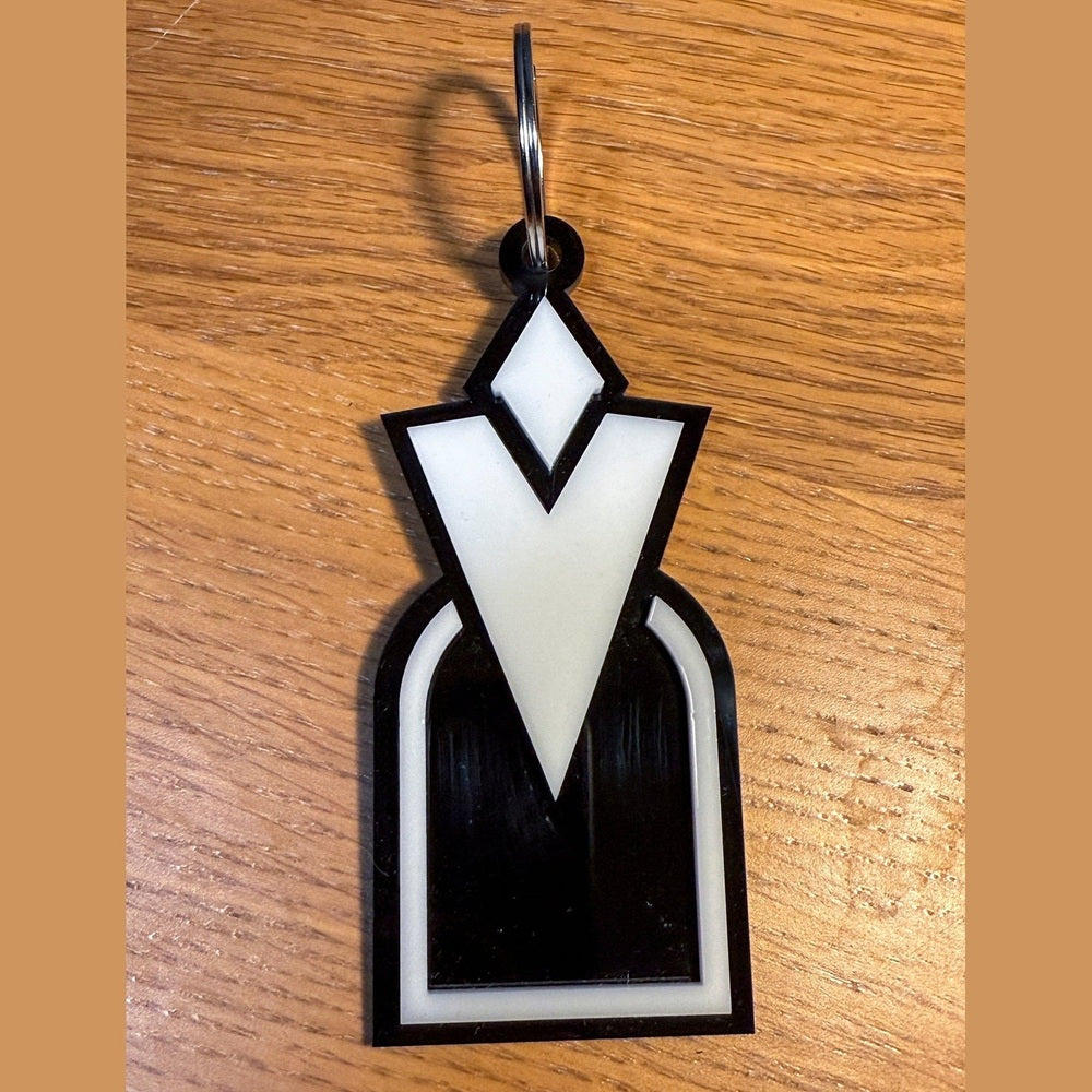 A 3D acrylic keyring featuring a white Skyrim inspired Quest Marker icon on a black background.