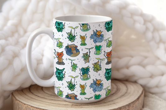 A white ceramic mug displays a pattern of Korok characters from The Legend of Zelda: Breath of the Wild and Tears of the Kingdom.