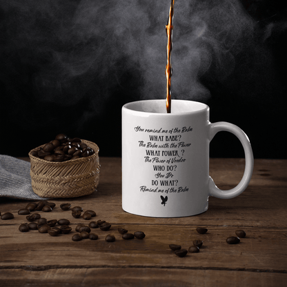 Steaming coffee being poured into a Labyrinth movie mug with Dance Magic lyrics, surrounded by coffee beans on a wooden surface.
