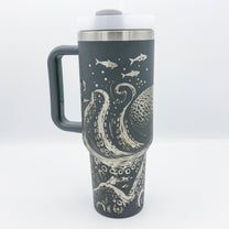 A dark gray 40oz tumbler features an engraved design of a Kraken octopus and several fish, inspired by D&D and Cthulu themes.